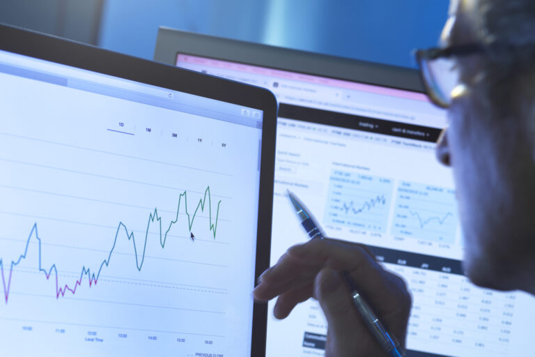 Financial services, stock analyst researching share price data of a company on the computer